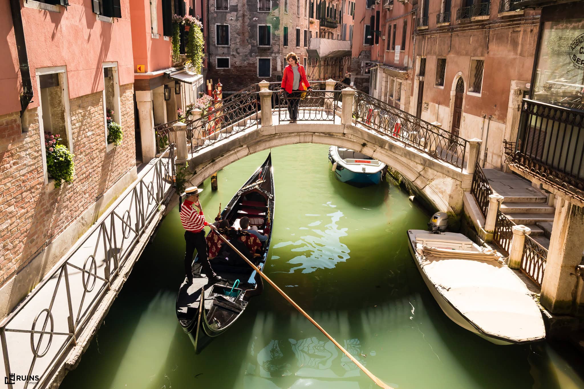 Небольшой арочный пешеходный мост через жилой канал в историческом центре Венеции. Венеция, Италия. Городская архитектура XVII–XIX вв.