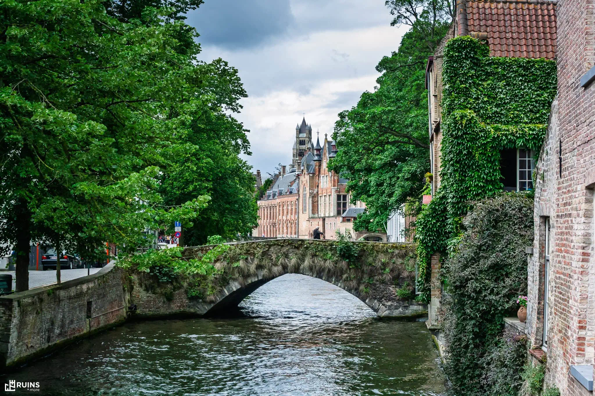 Старый каменный арочный мост через канал в историческом центре Брюгге, Бельгия. Средневековое мостостроение.