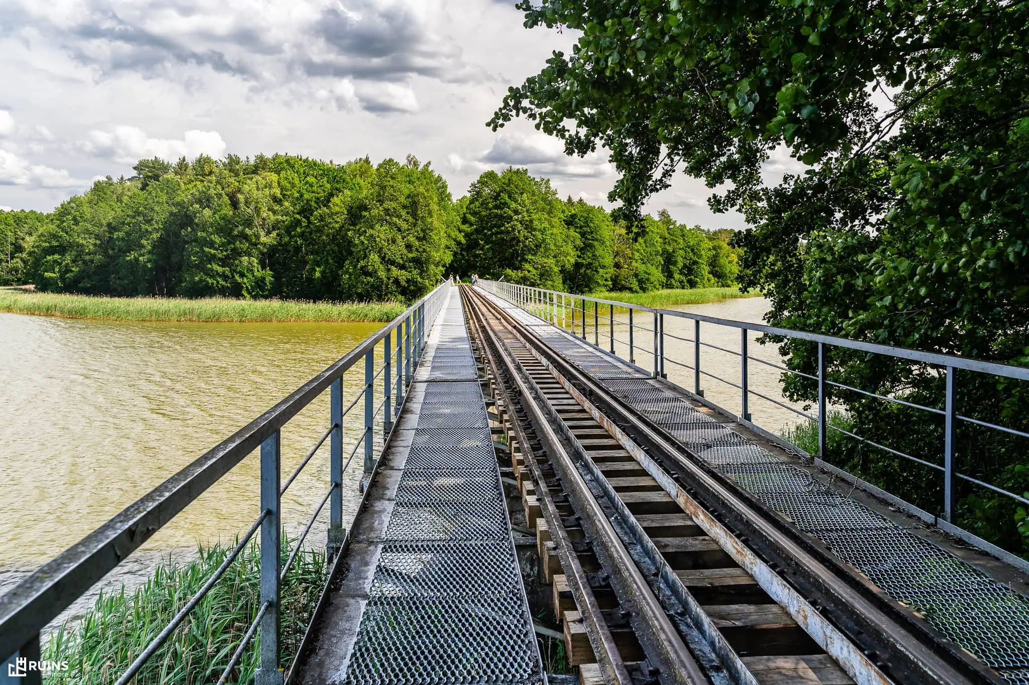 Железнодорожный мост узкоколейной линии через озеро Белое (вид по оси моста). Заказник «Озёрный», Беларусь. Середина XX в.